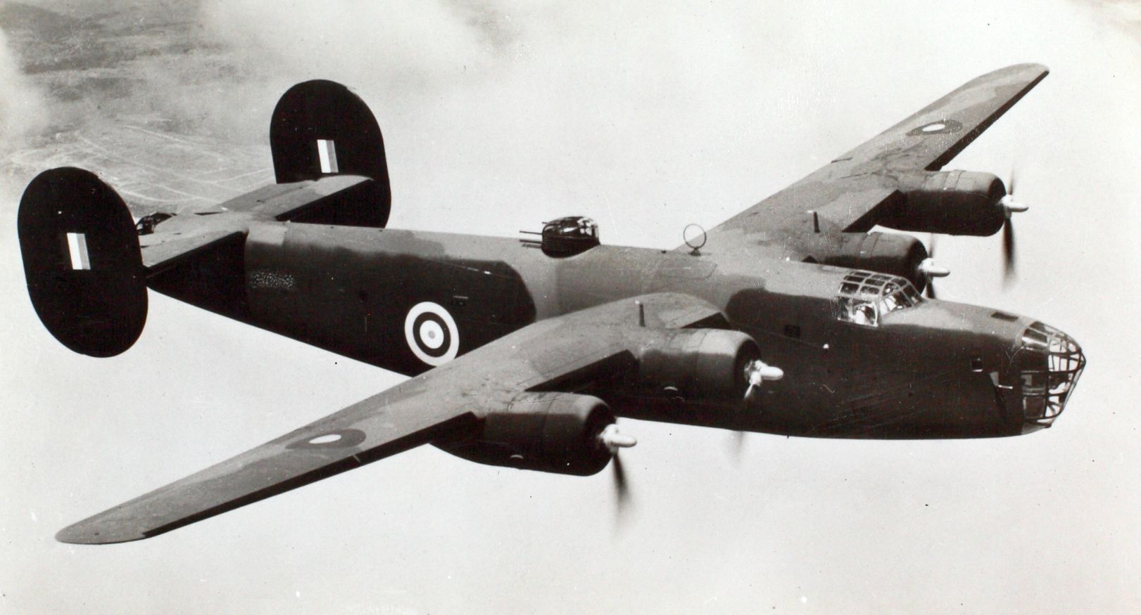 A black and white image of a Liberator bomber in flight.