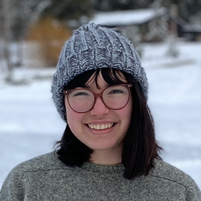 headshot of Nathalie, a chinese-canadian mixed-race woman with shoulder length hair wearing a toque and glasses in a snowy park.