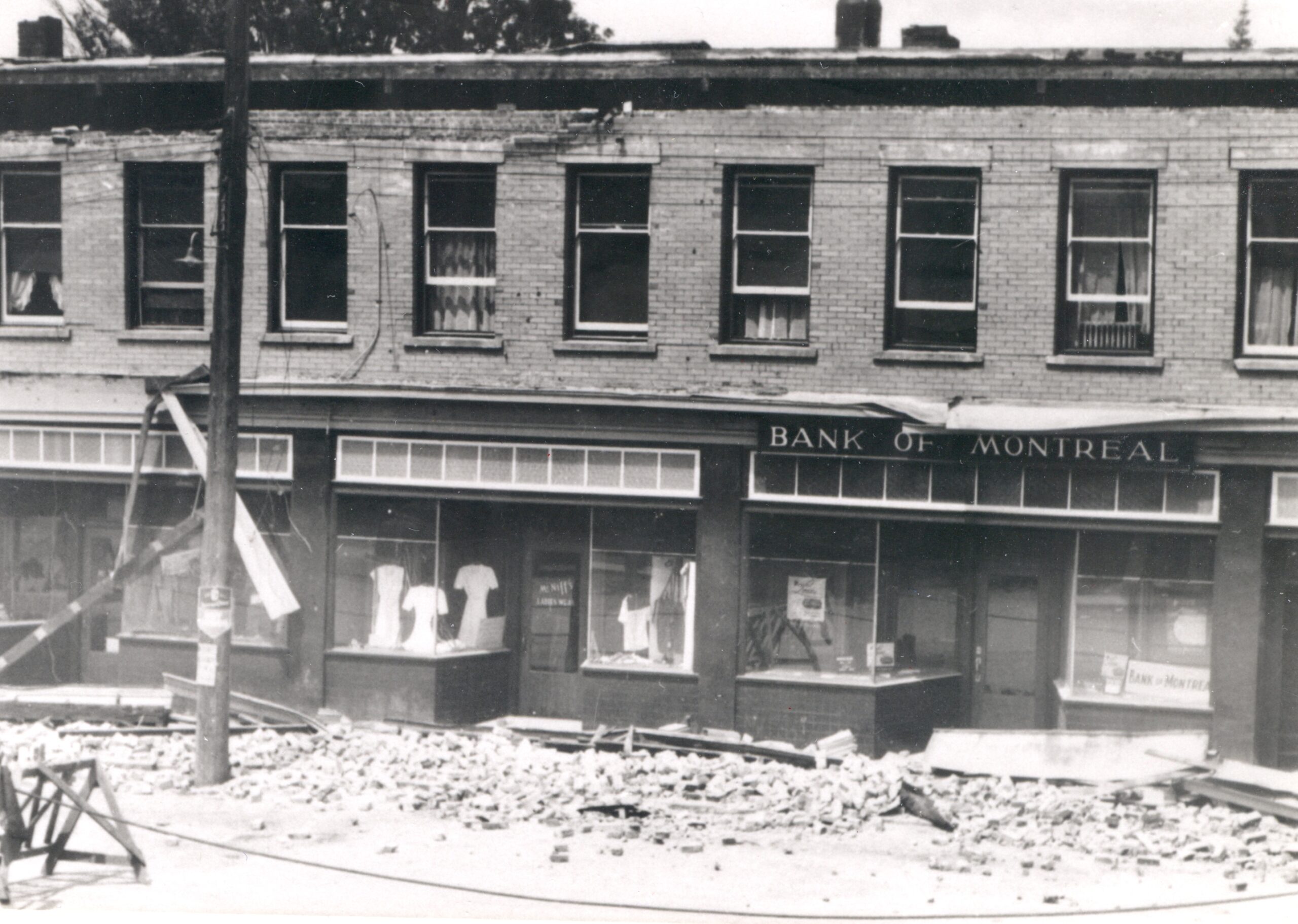 black and white view of a historic storefront in Port Alberni. Rubble in front of it from an earthquake.