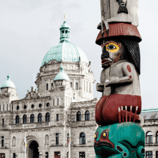 Totem Pole with BC parliament building in the background stock image