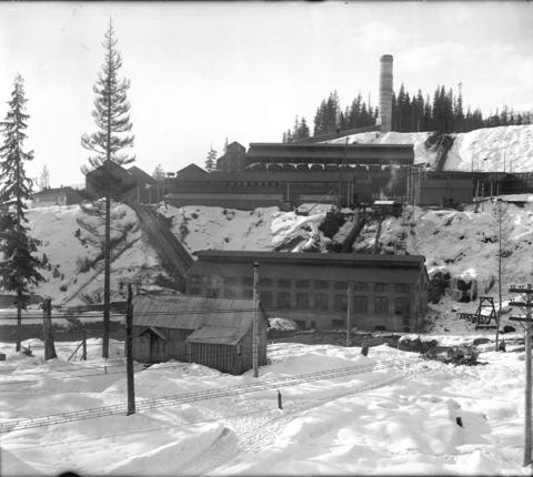 Historic photograph of the smelter at Grandforks surrounded by snow and sparse trees in the winter of 1910.