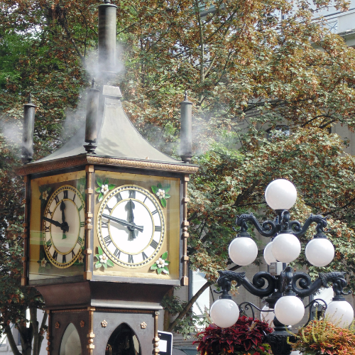 Vancouver Gastown steam clock with a leafy tree behind it